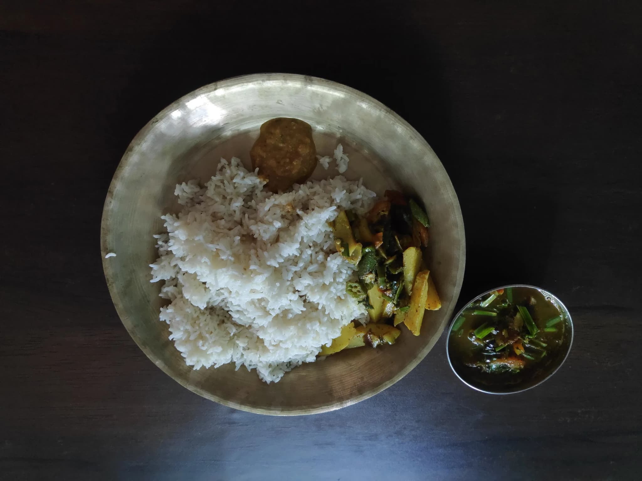 A plate of dal bhat: rice, lentil soup, vegetable curry and pickle